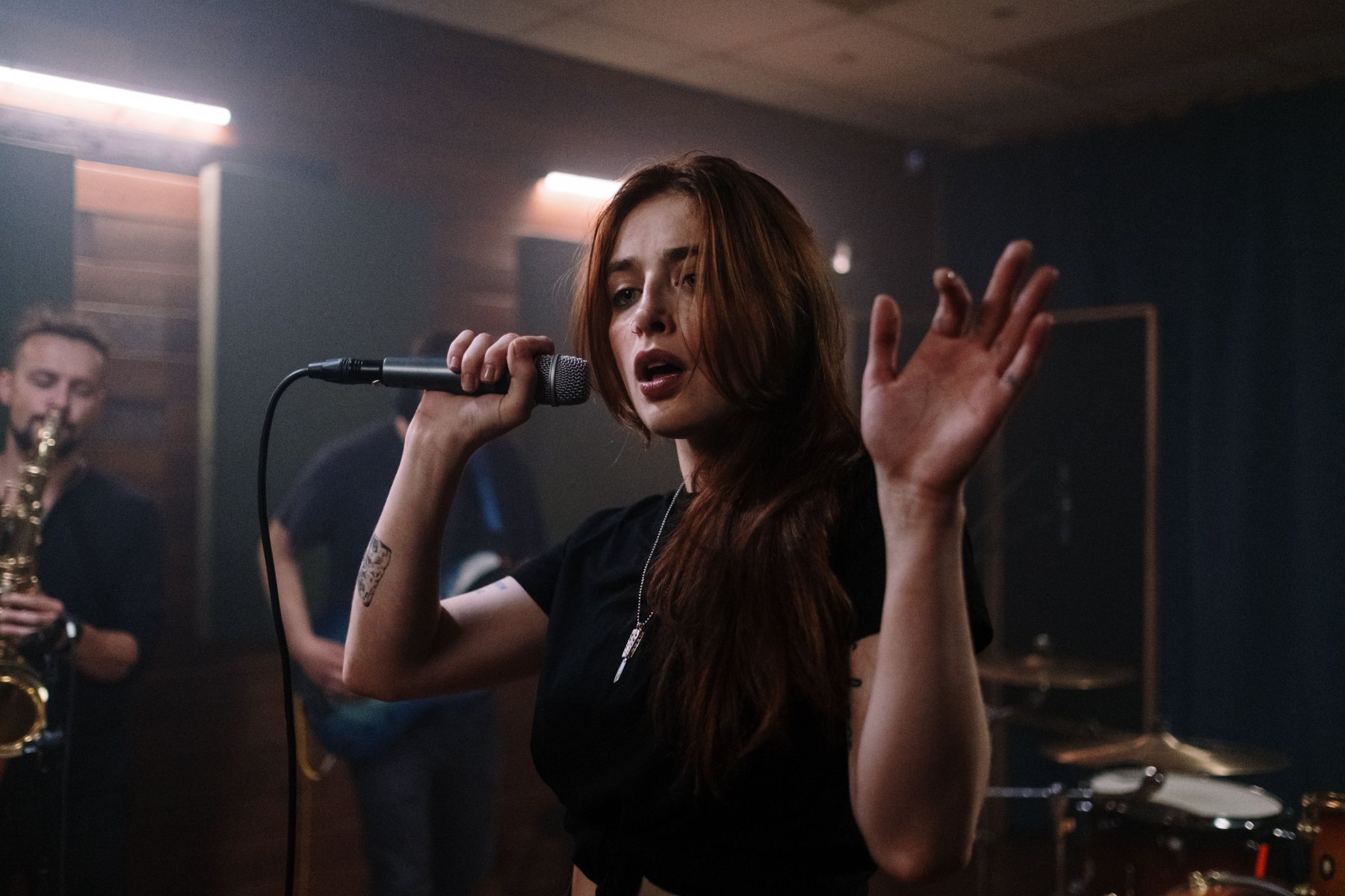 A singer performing with a live band during a vocal session